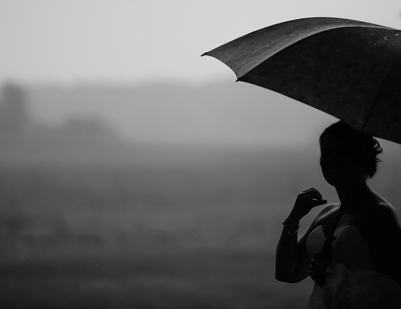 bride holding an umbrella on her wedding day on her family farm in Iowa