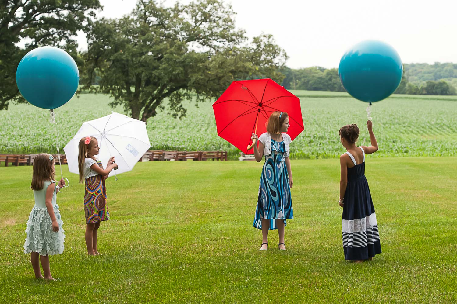 girls holding umbrellas and balloons on an Iowa Farm