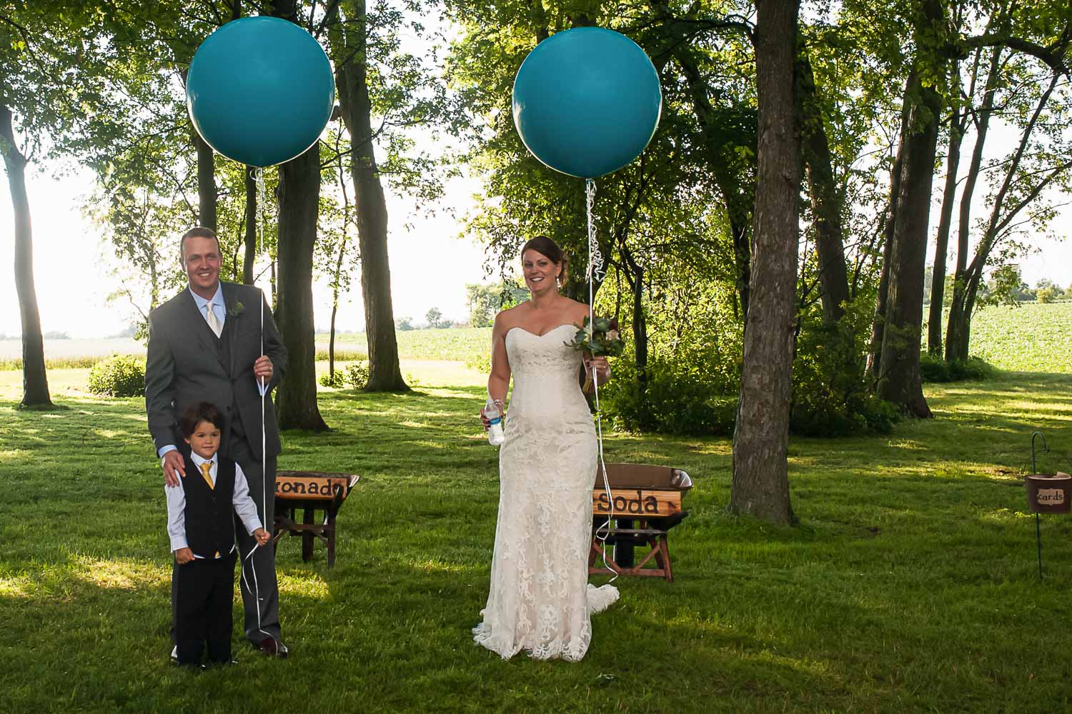 bride and groom holding large balloons on their wedding day 