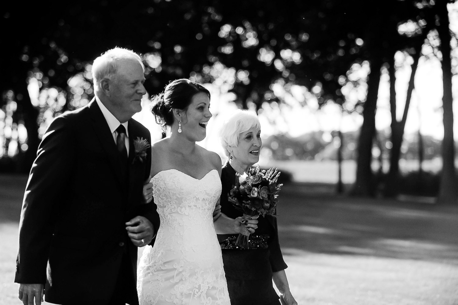 bride walking down the aisle with her mom and dad on their Iowa Farm