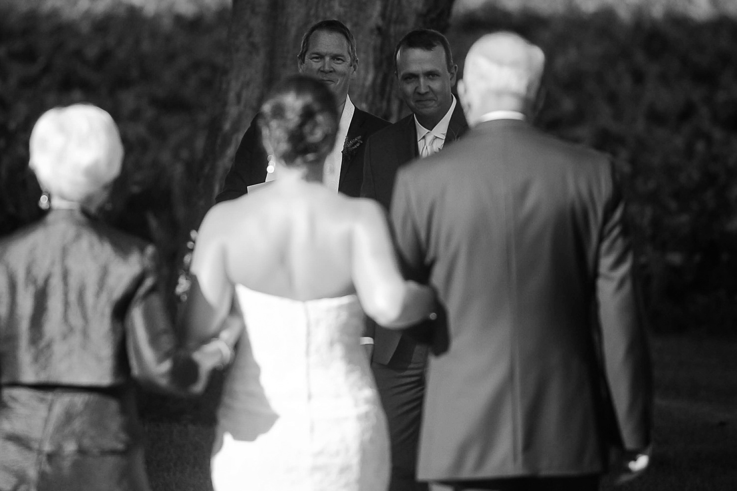 groom watching his bride walk down the aisle at their Iowa Farm wedding