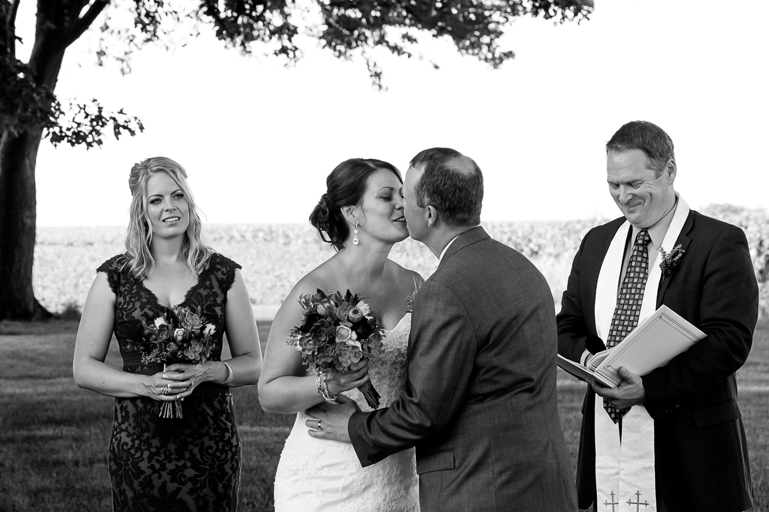 bride and groom exchanging their first kiss after their ceremony at the family Iowa farm