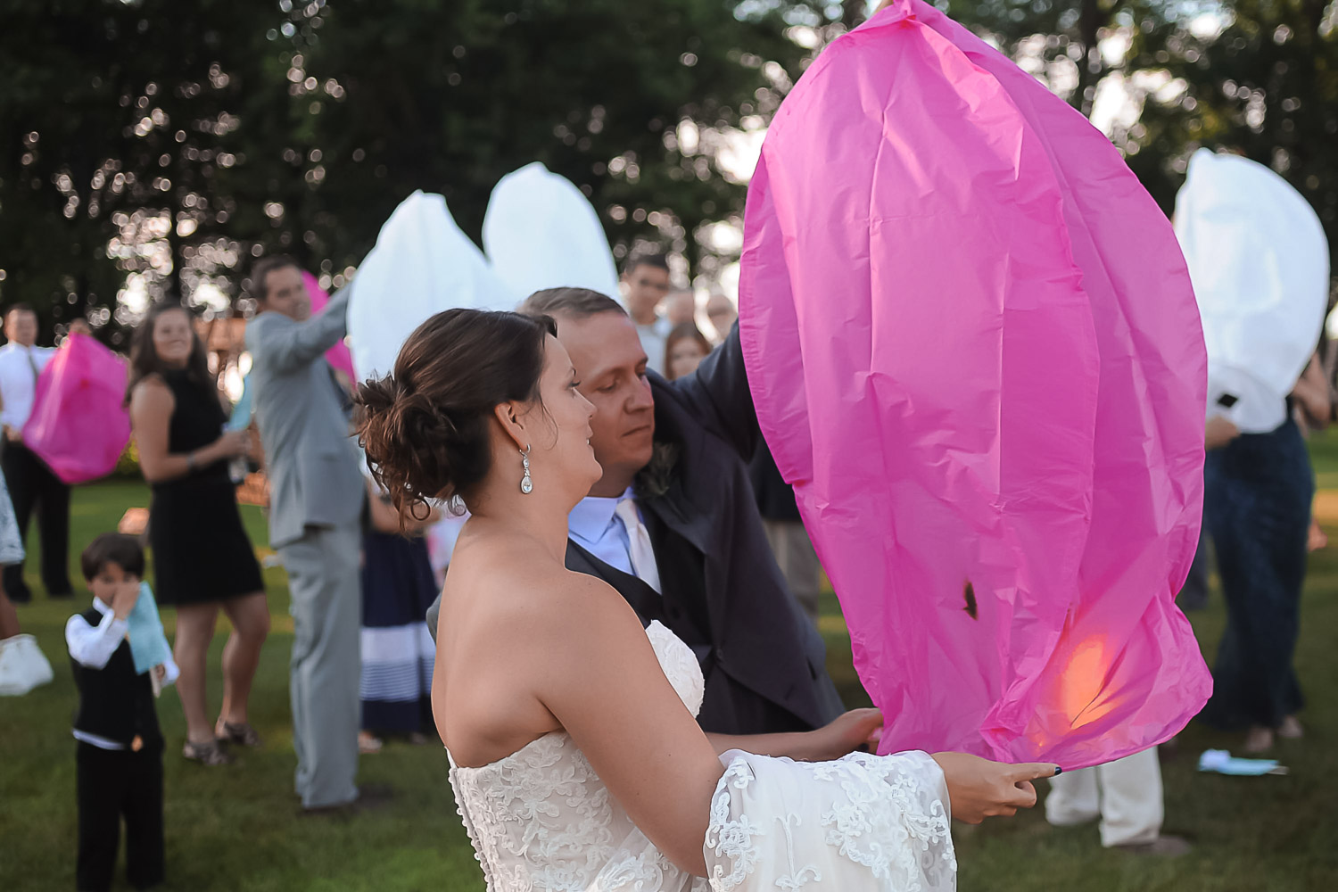 bride and groom lighting paper lanterns during their Iowa Farm wedding