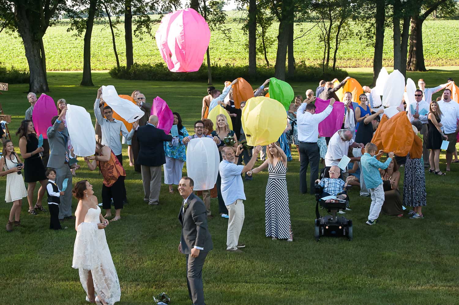 bride and groom lighting paper lanterns during their Iowa Farm wedding