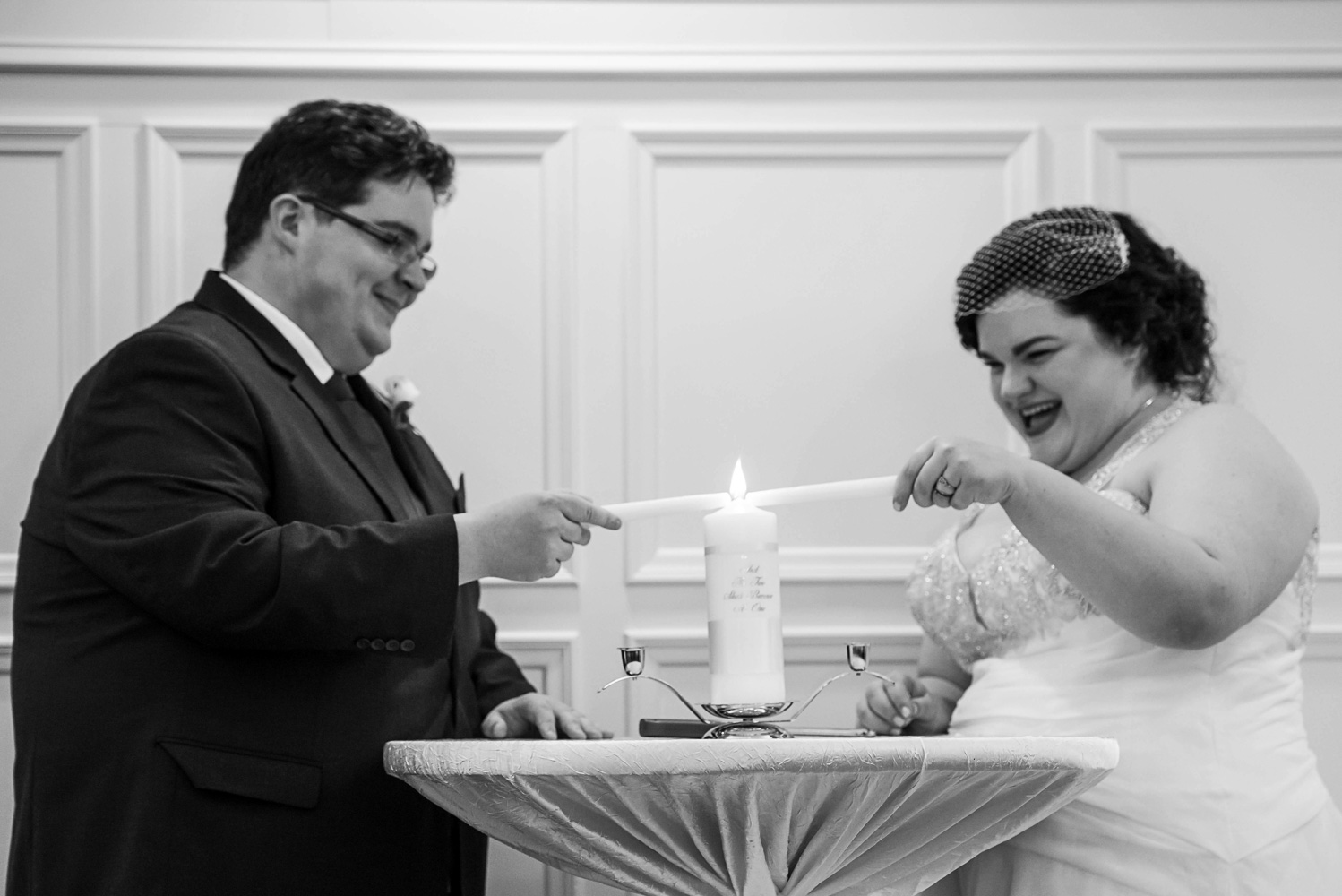 bride and groom lighting the unity candle at the St Paul College Club