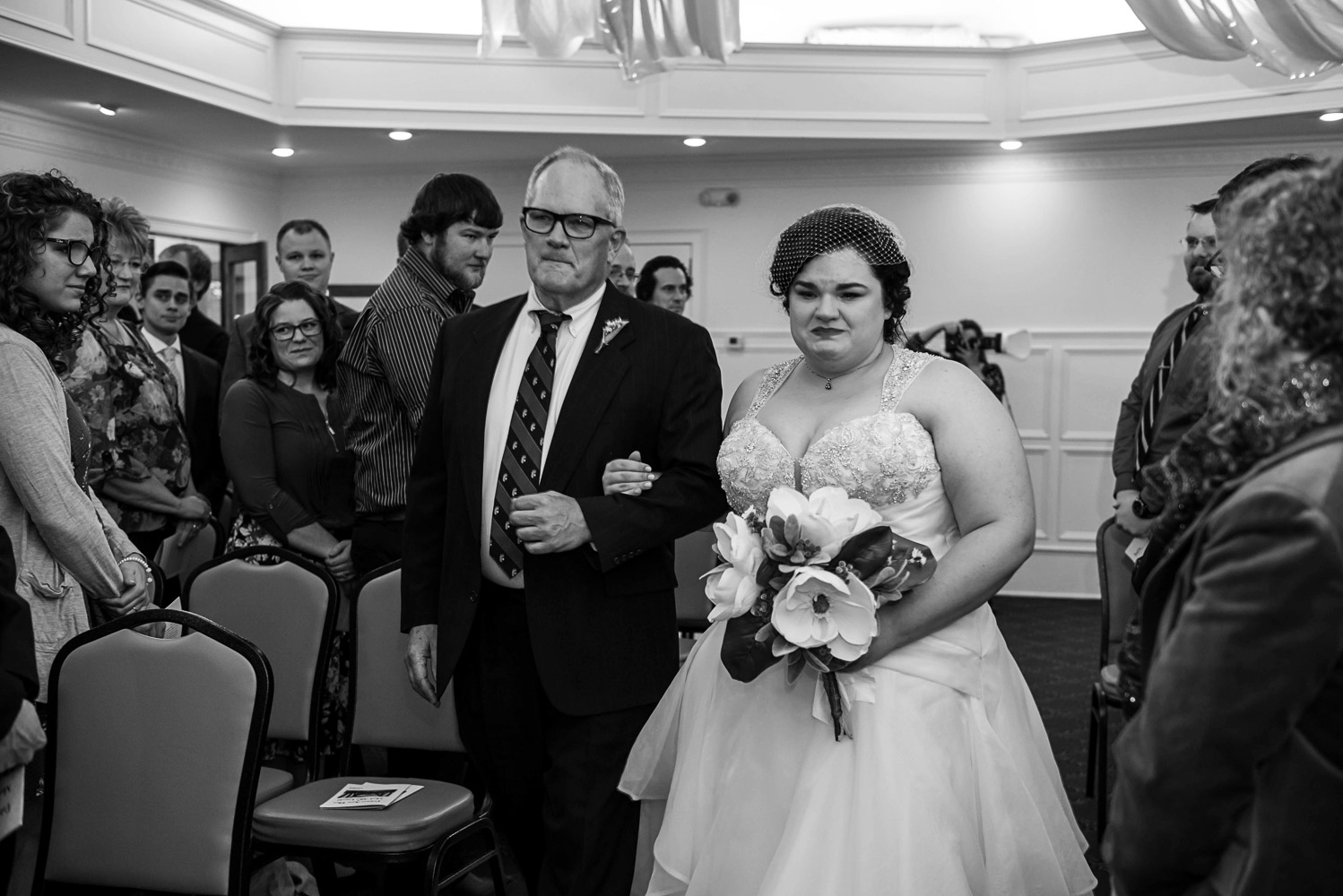 bride walking with father to during the processional at the St Paul College Club in Minnesota