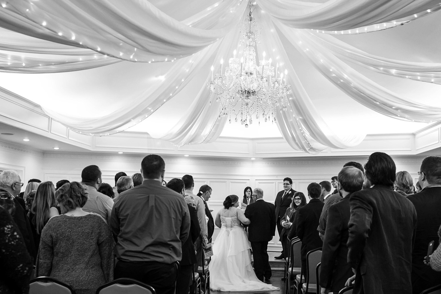 groom watching the bride and her dad walking down the aisle at their St Paul College Club wedding