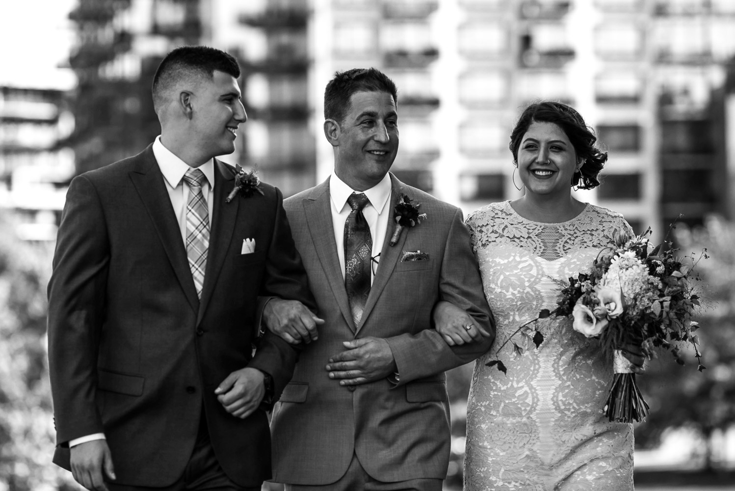 groom walking with his kids to his wedding ceremony at Gold Medal Park in Minneapolis