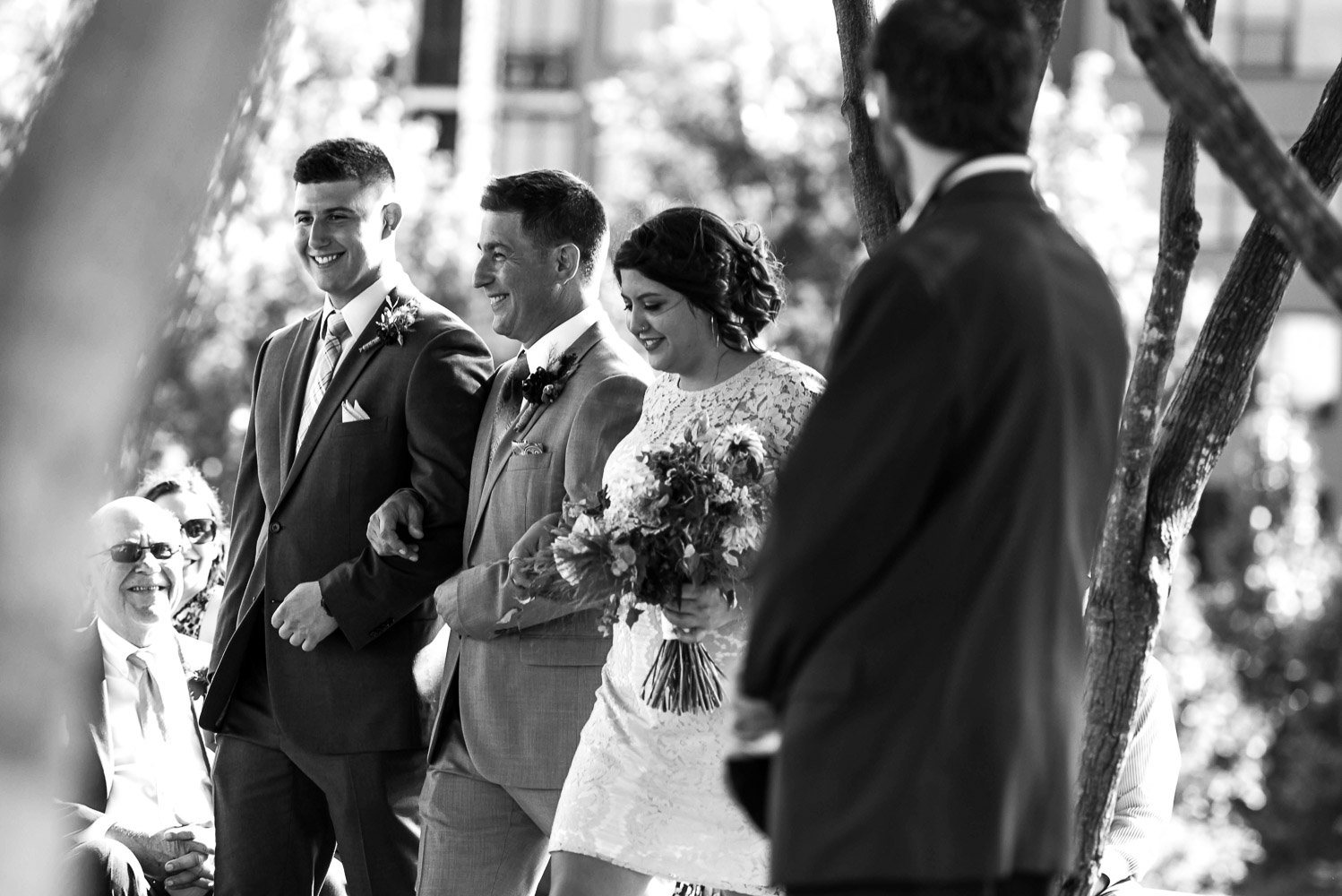 groom walking with his kids to the wedding ceremony at Gold Medal Park in Minneapolis