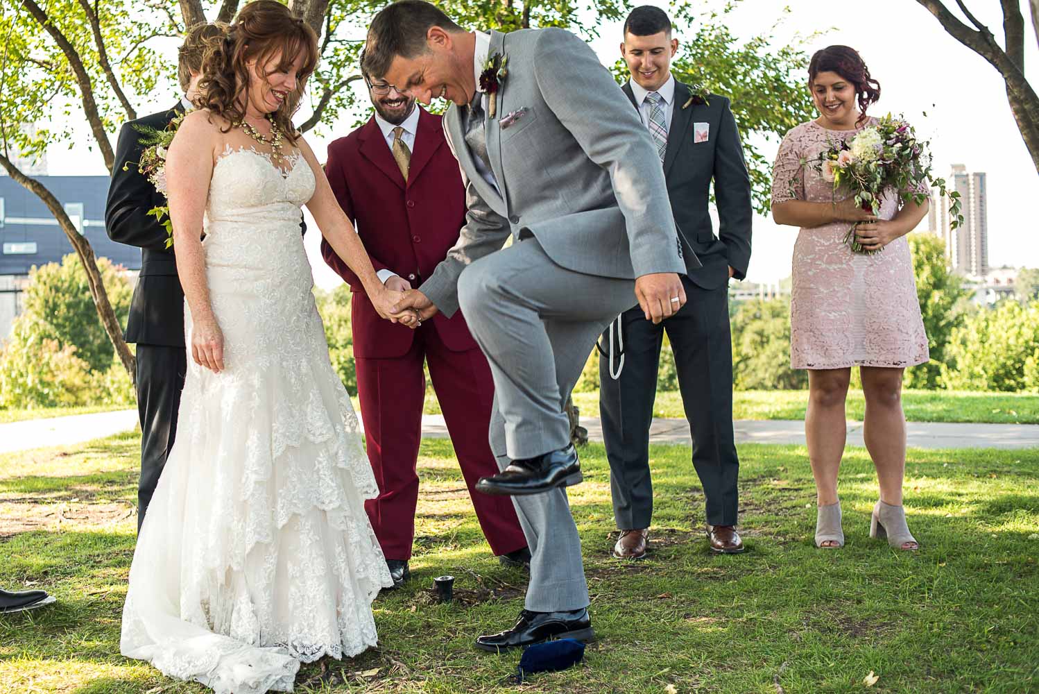 groom breaking the glass at the end of the wedding ceremony at Gold Medal Park