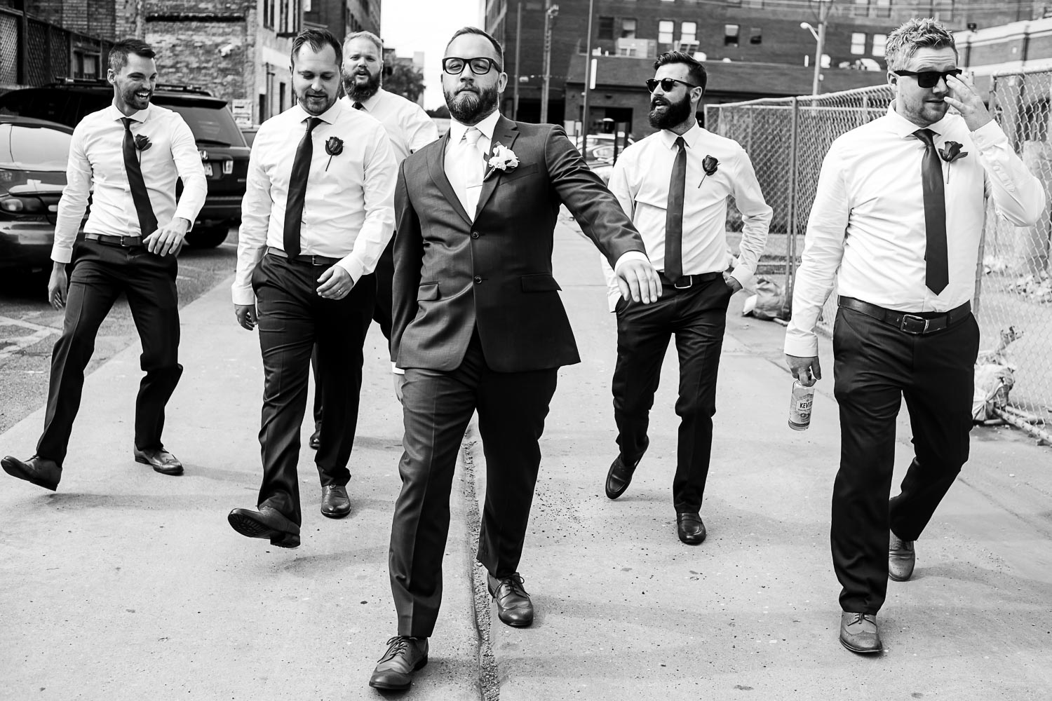 groom walking with his groomsmen in the warehouse district of Minneapolis