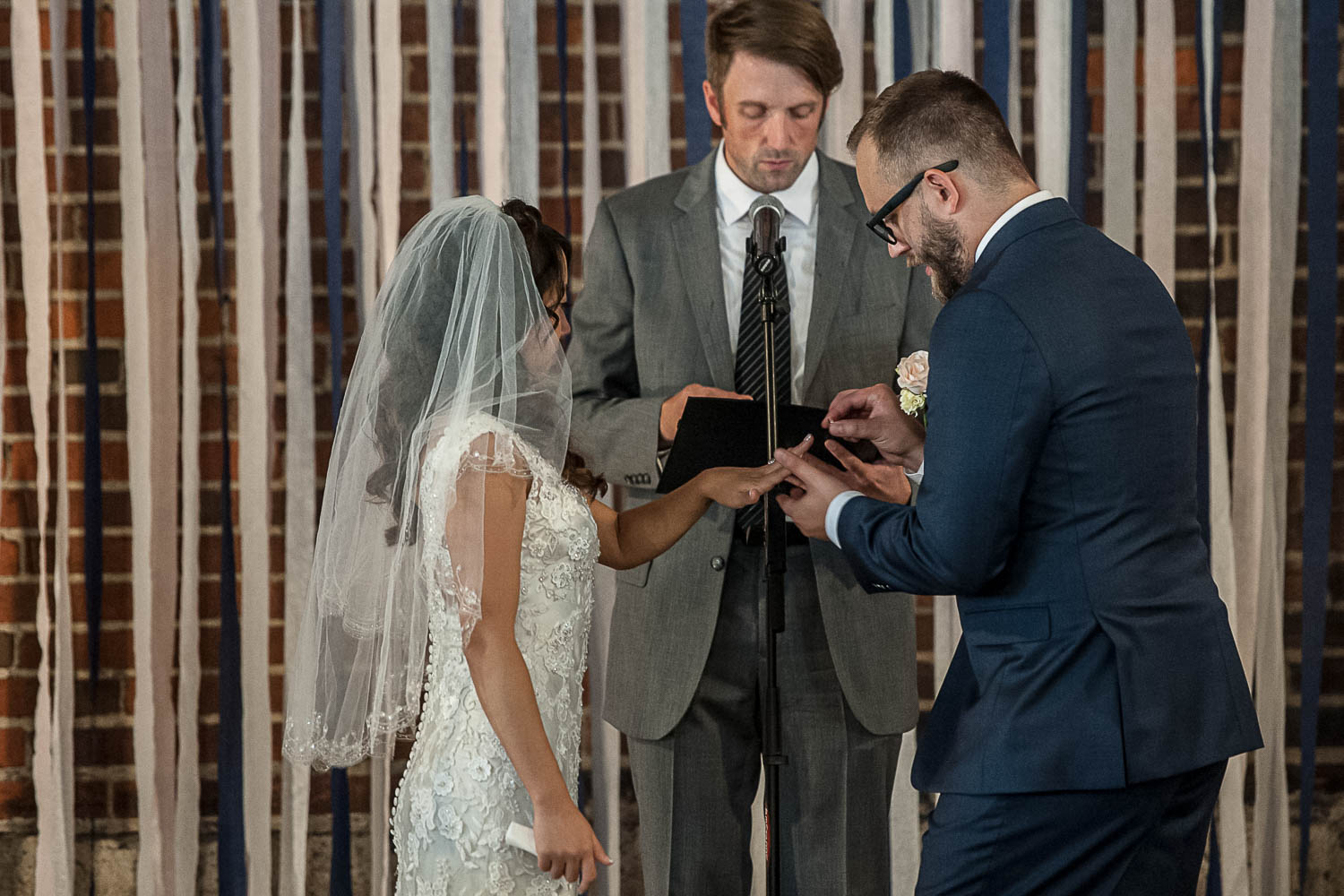 bride and groom exchanging rings during their wedding ceremony in Minneapolis