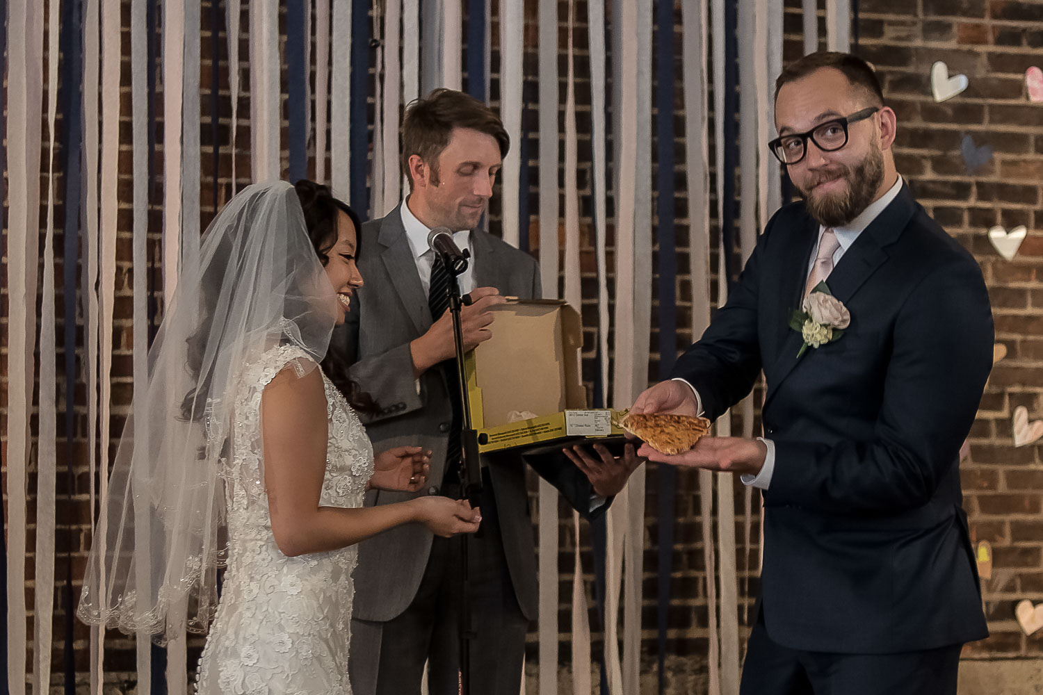 bride and groom eating pizza during their wedding ceremony at Neu Neu
