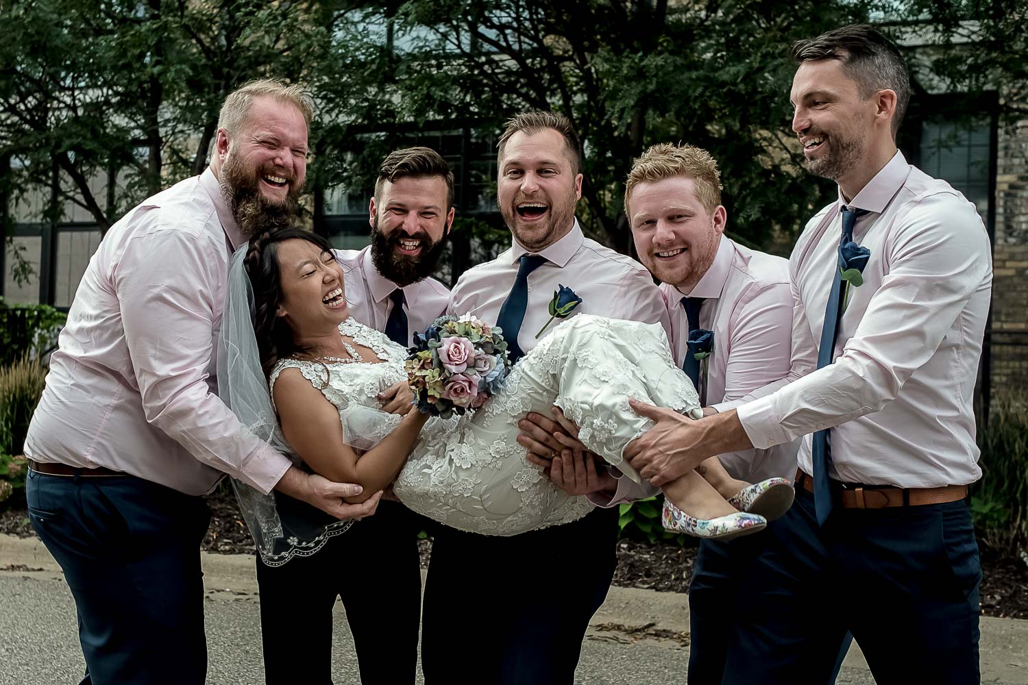 bride being held by the groomsmen during their wedding party portraits in Minneapolis