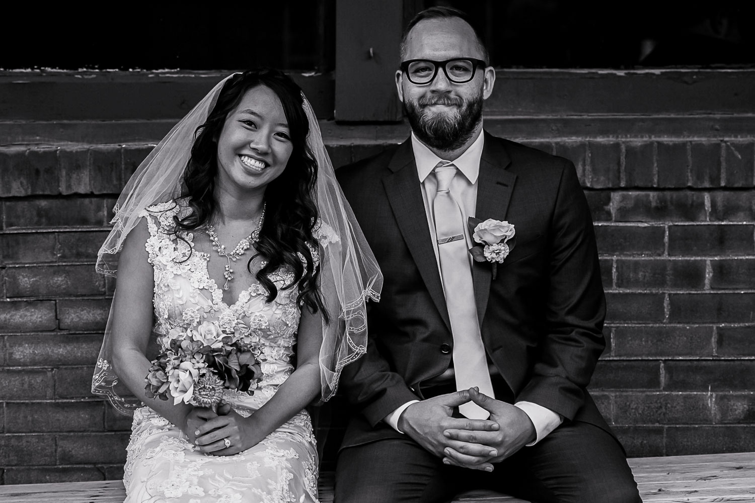 bride and groom sitting on a bench in front of Neu Neu in Minneapolis