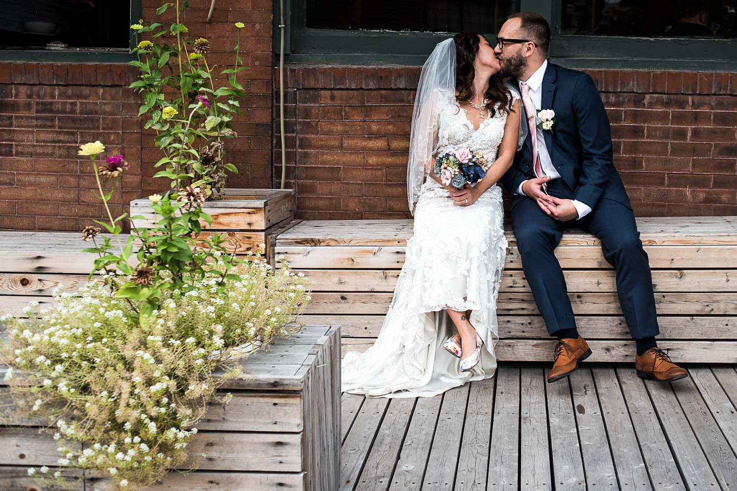 bride and groom sitting on a bench in front of Neu Neu in the North Loop