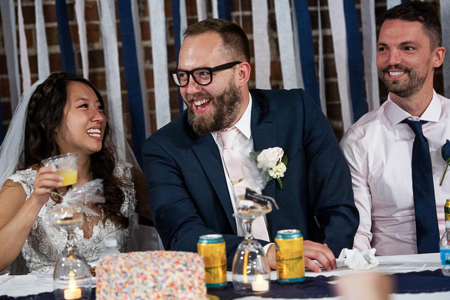 bride and groom sitting laughing during the speeches at their Minneapolis wedding reception