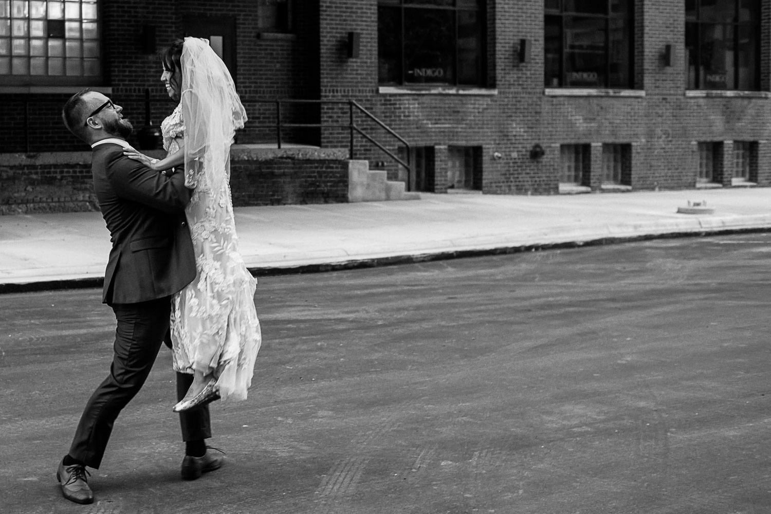 groom picking up and twirling the bride in the industrial area of Minneapolis