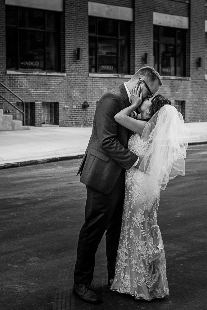 bride and groom kissing in an industrial area of Minneapolis