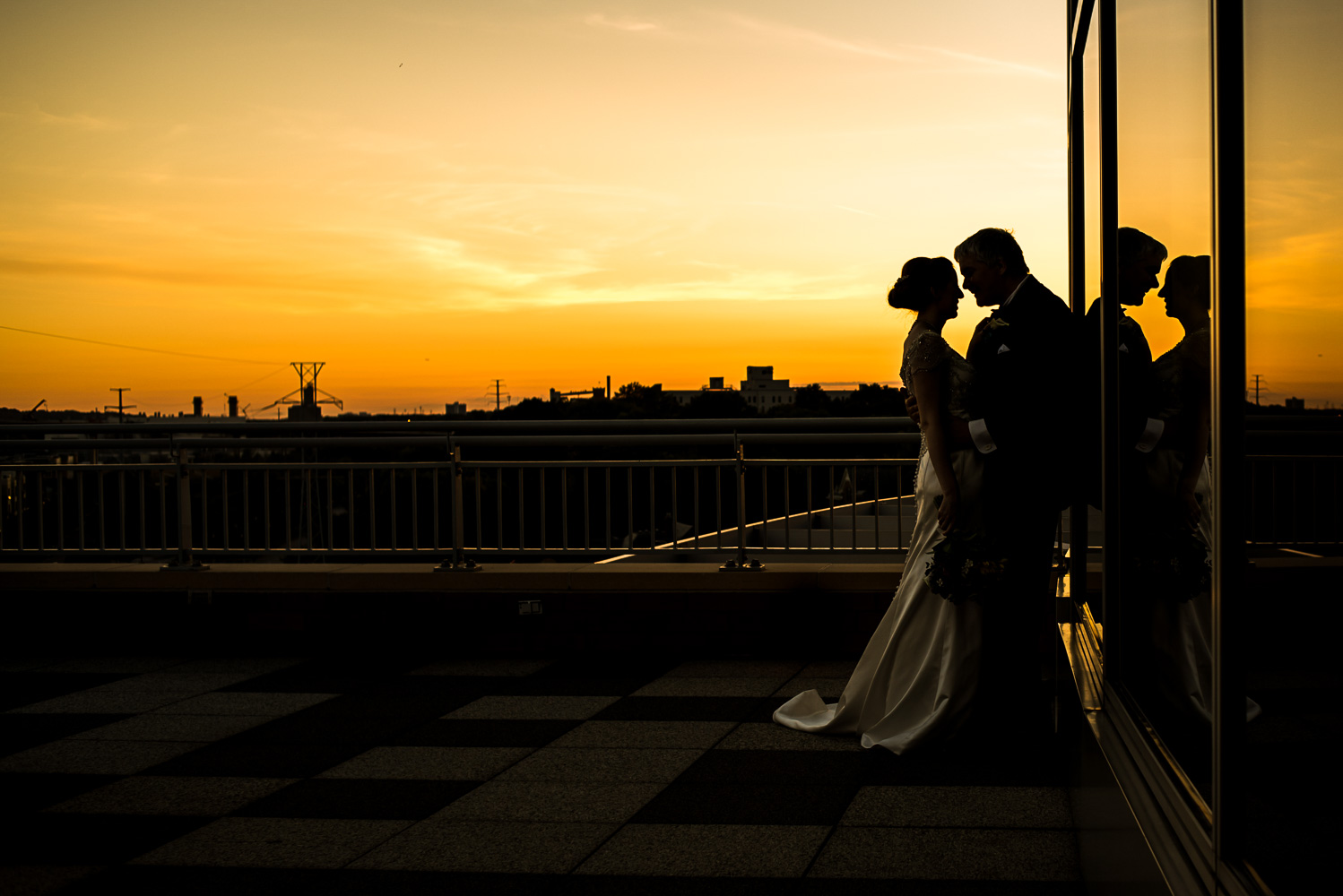 silhouette of the bride and groom at sunset on the balcony at the St Paul Science Museum