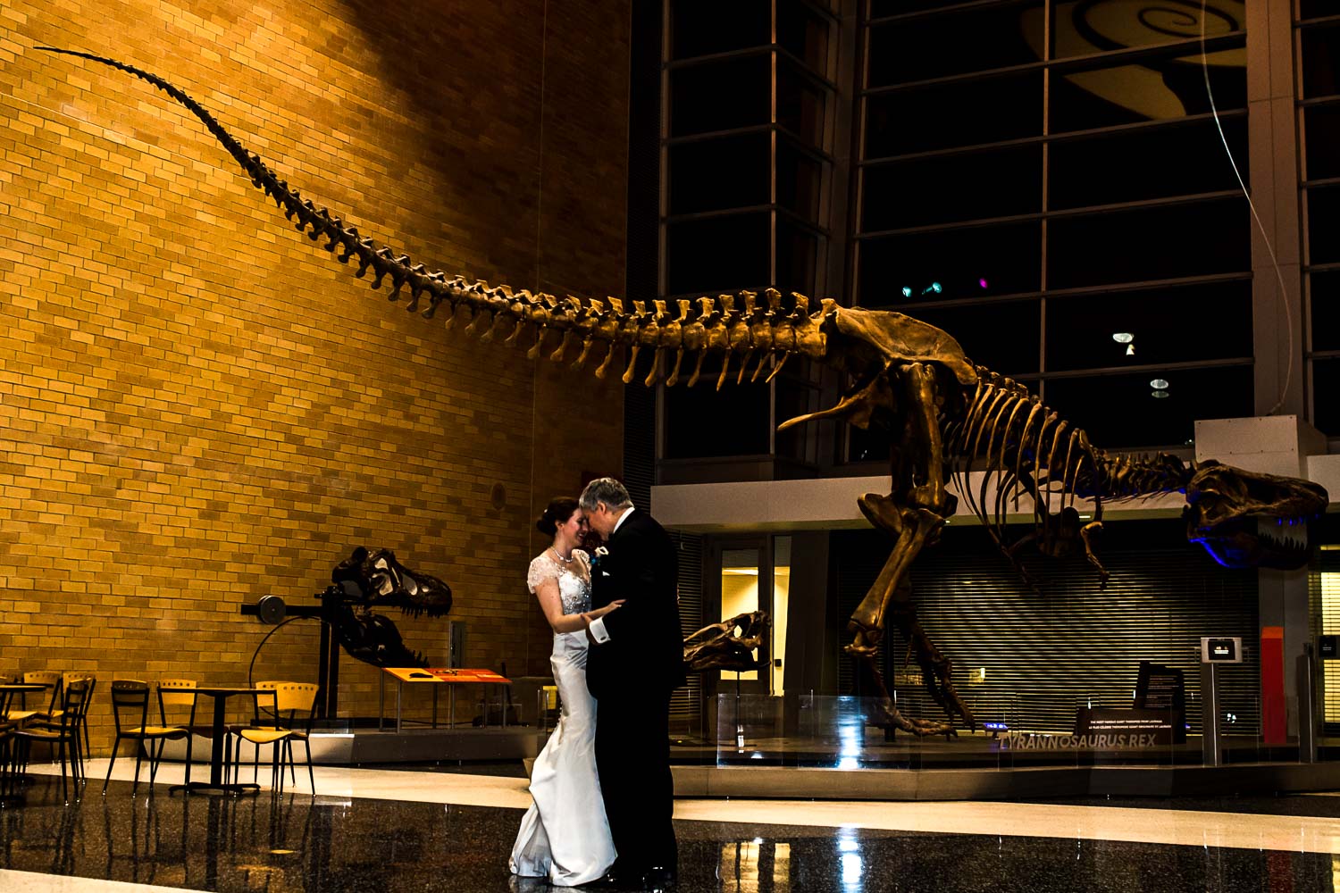 bride and groom at their Science Museum wedding dancing next to the T-Rex 