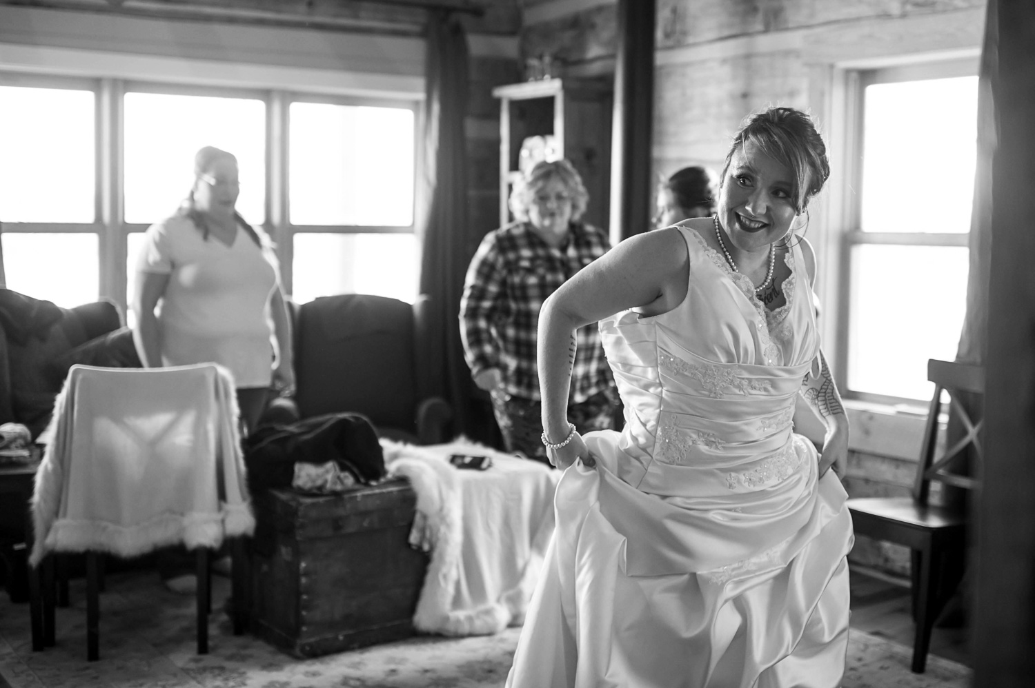bride putting on her wedding dress for her winter wedding