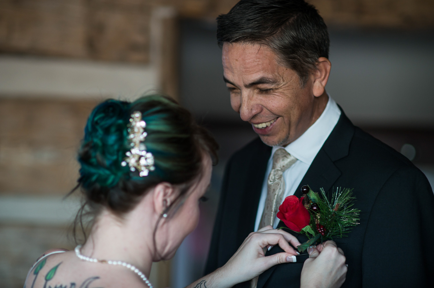 bride pinning the boutonniere on her dad at her winter wedding 