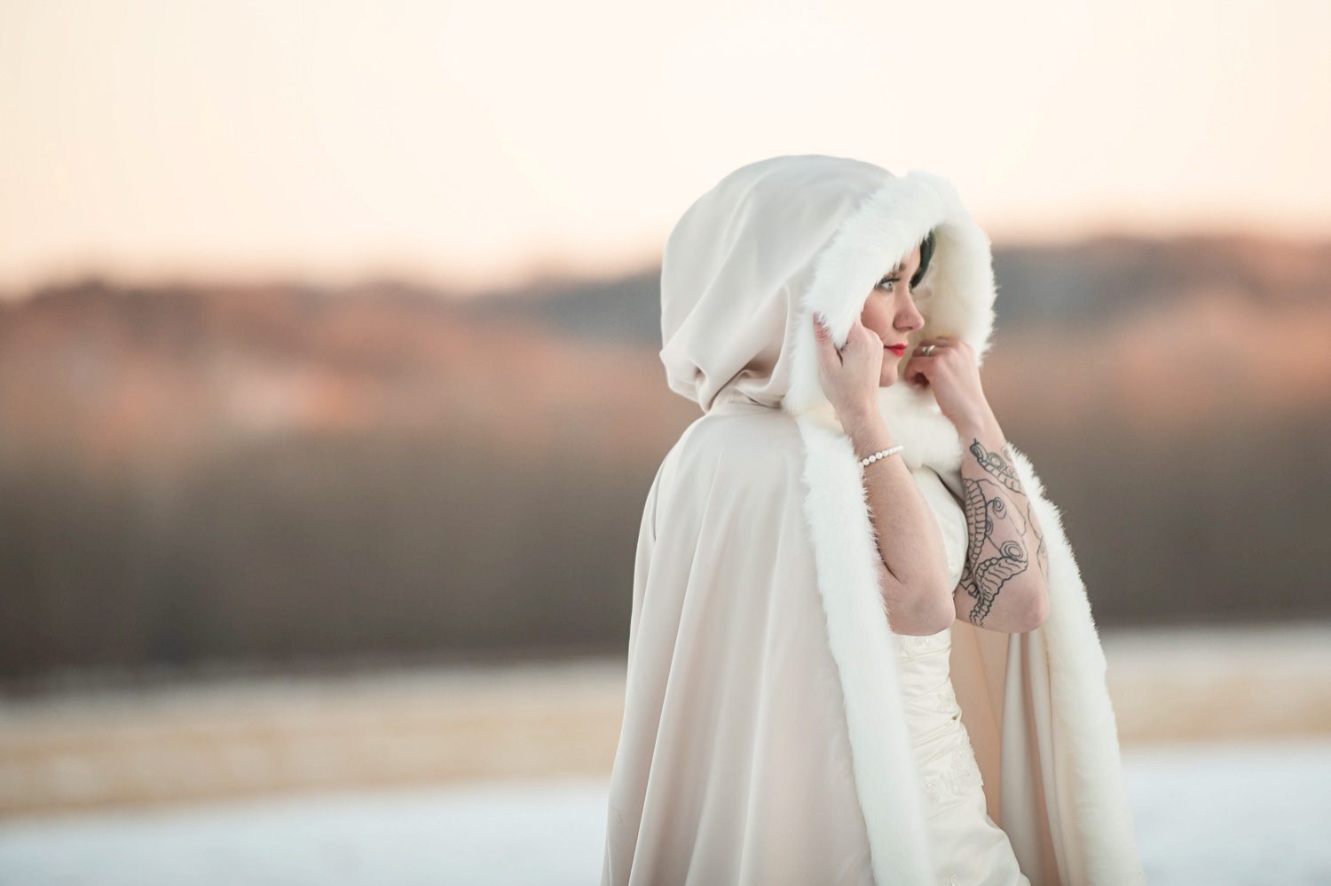 Minnesota winter wedding with the bride in a white cloak