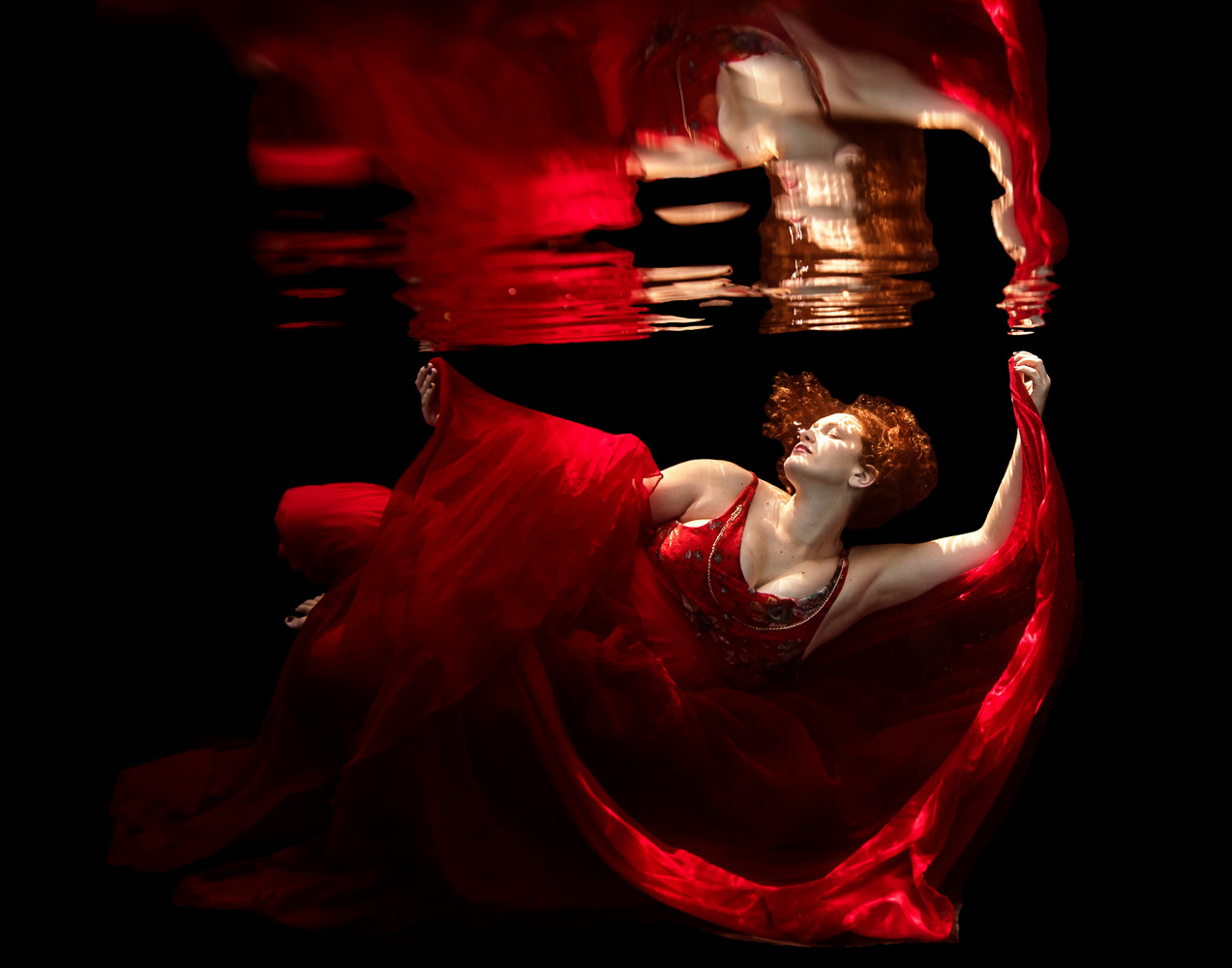 woman in a red dress during her underwater fashion shoot