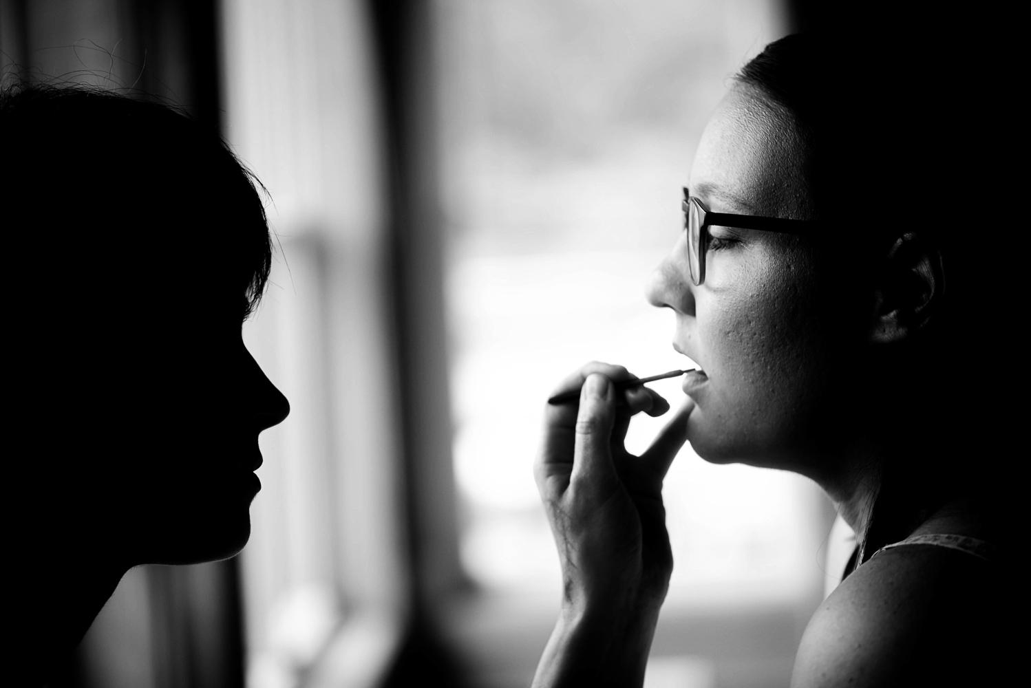 bride getting her lipstick on while getting ready with her summer wedding in Minnesota