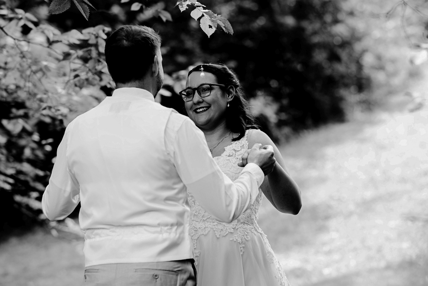 bride and groom holding hands during their first look at their home for their summer wedding