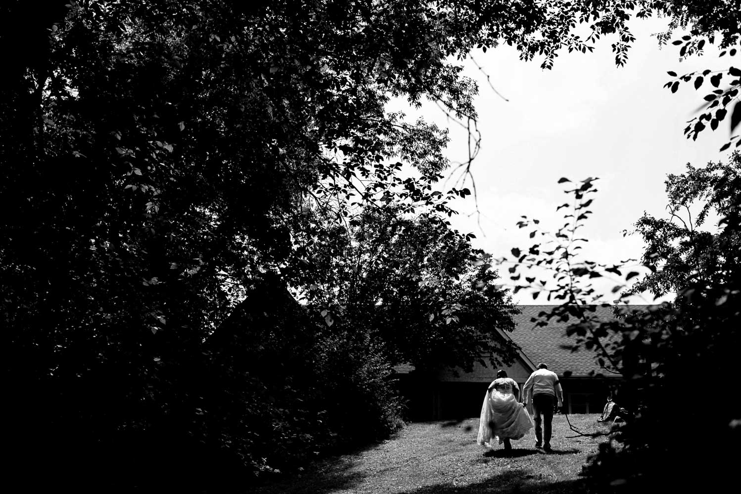 bride and groom walking in their yard before their summer wedding at home