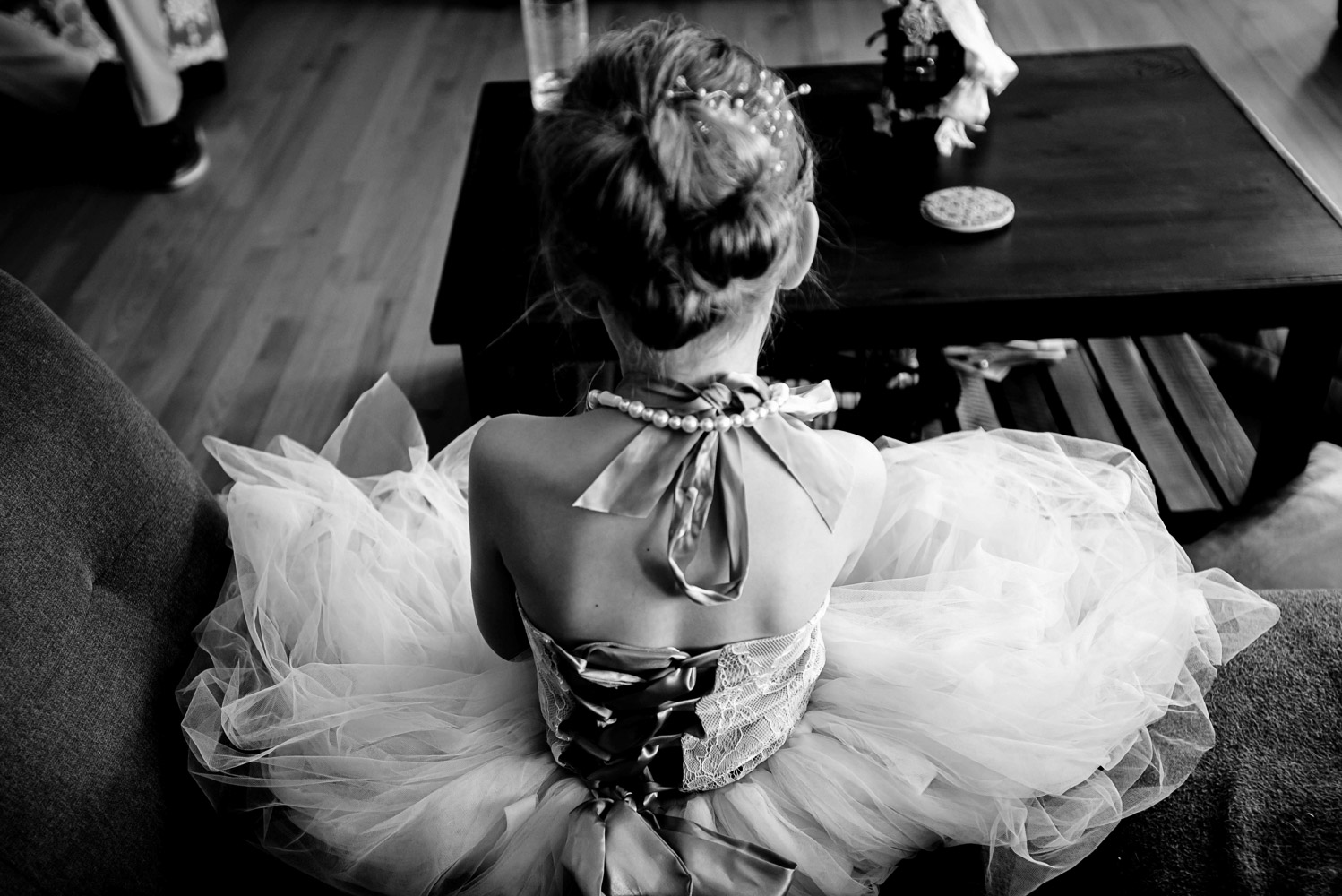 flower girl sitting and playing a game before the summer wedding