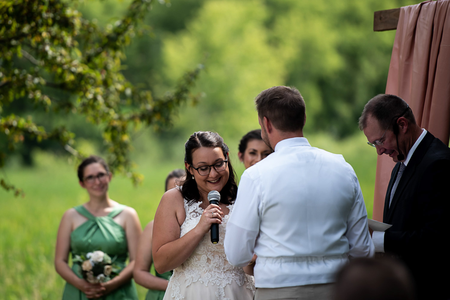 bride reading her vows to the groom during their ceremony at their summer wedding at home