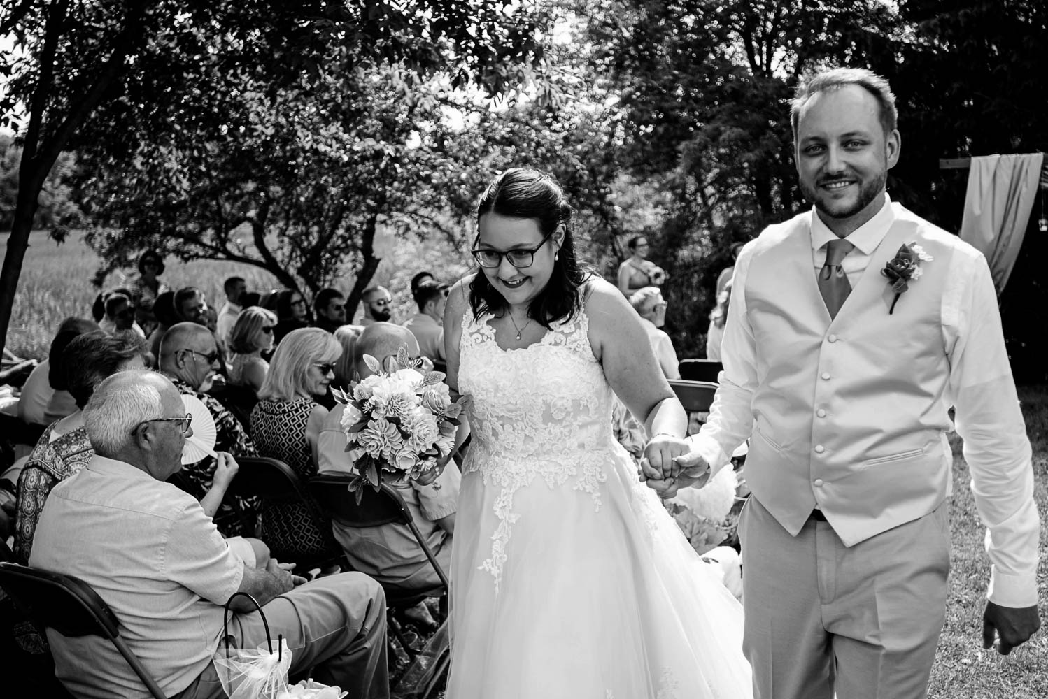 bride and groom laughing and walking down the aisle after their wedding ceremony