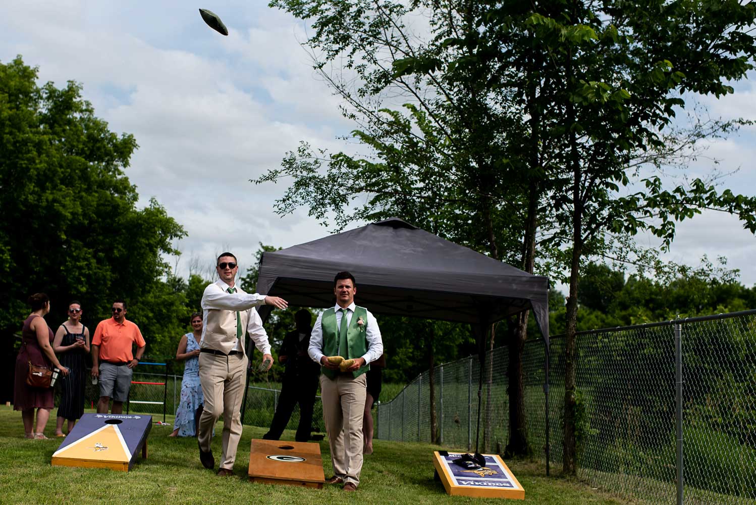 wedding guests playing yard games during the wedding reception at the bride and groom's home in Minnesota