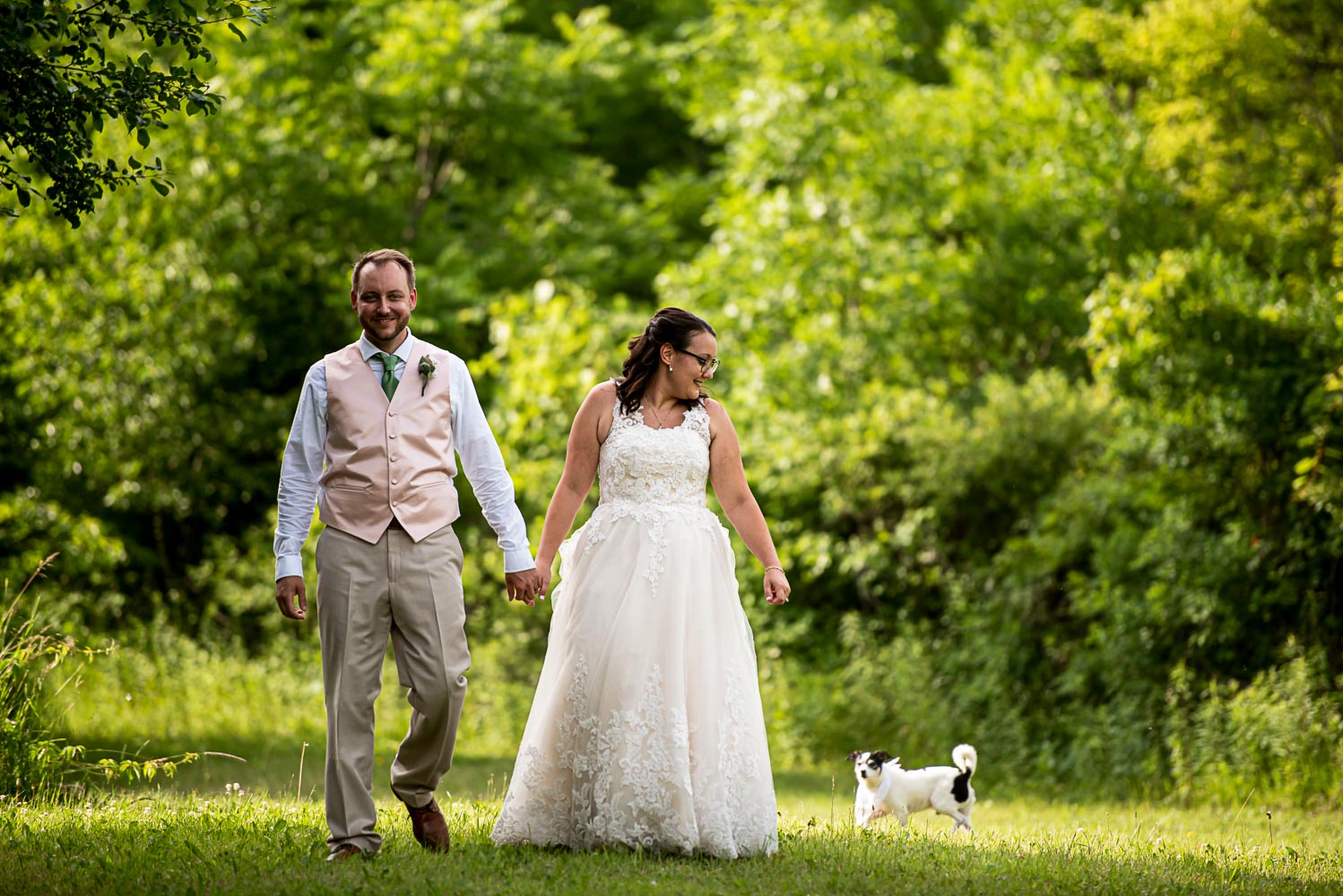 bride and groom walking with the dog after their summer wedding at home