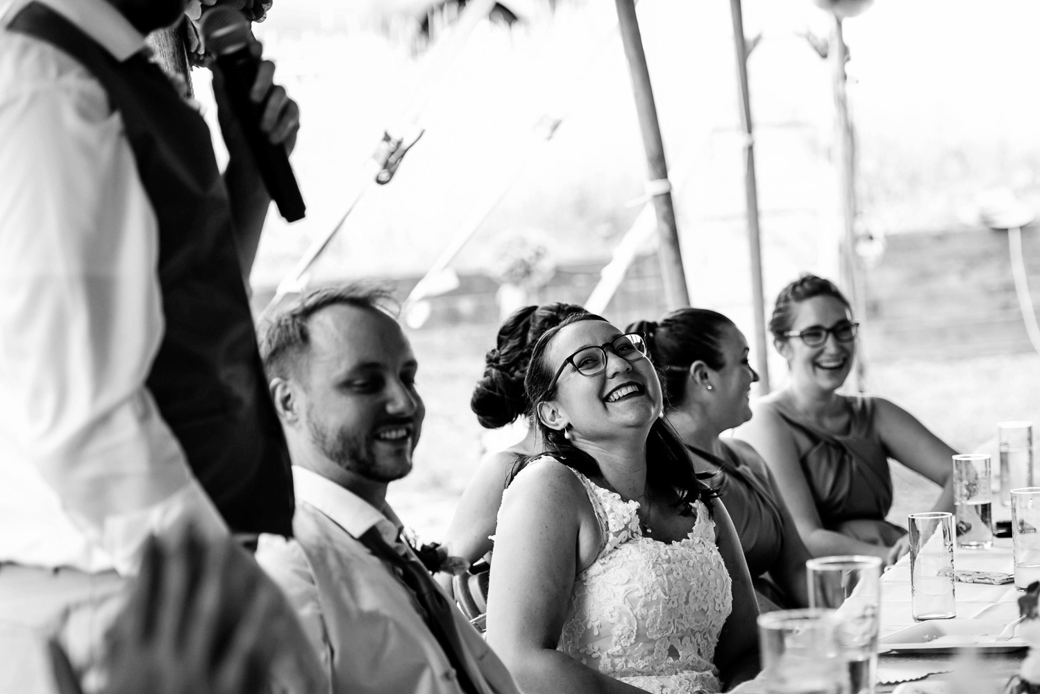 bride and groom laughing during speeches at their summer wedding at their home
