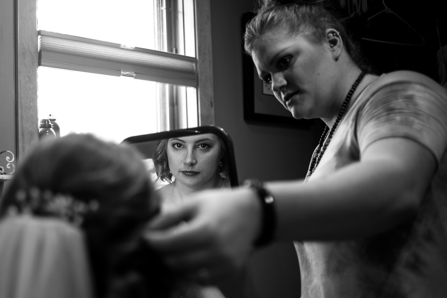 bride looking at herself in the mirror while getting ready in Northern Minnessota