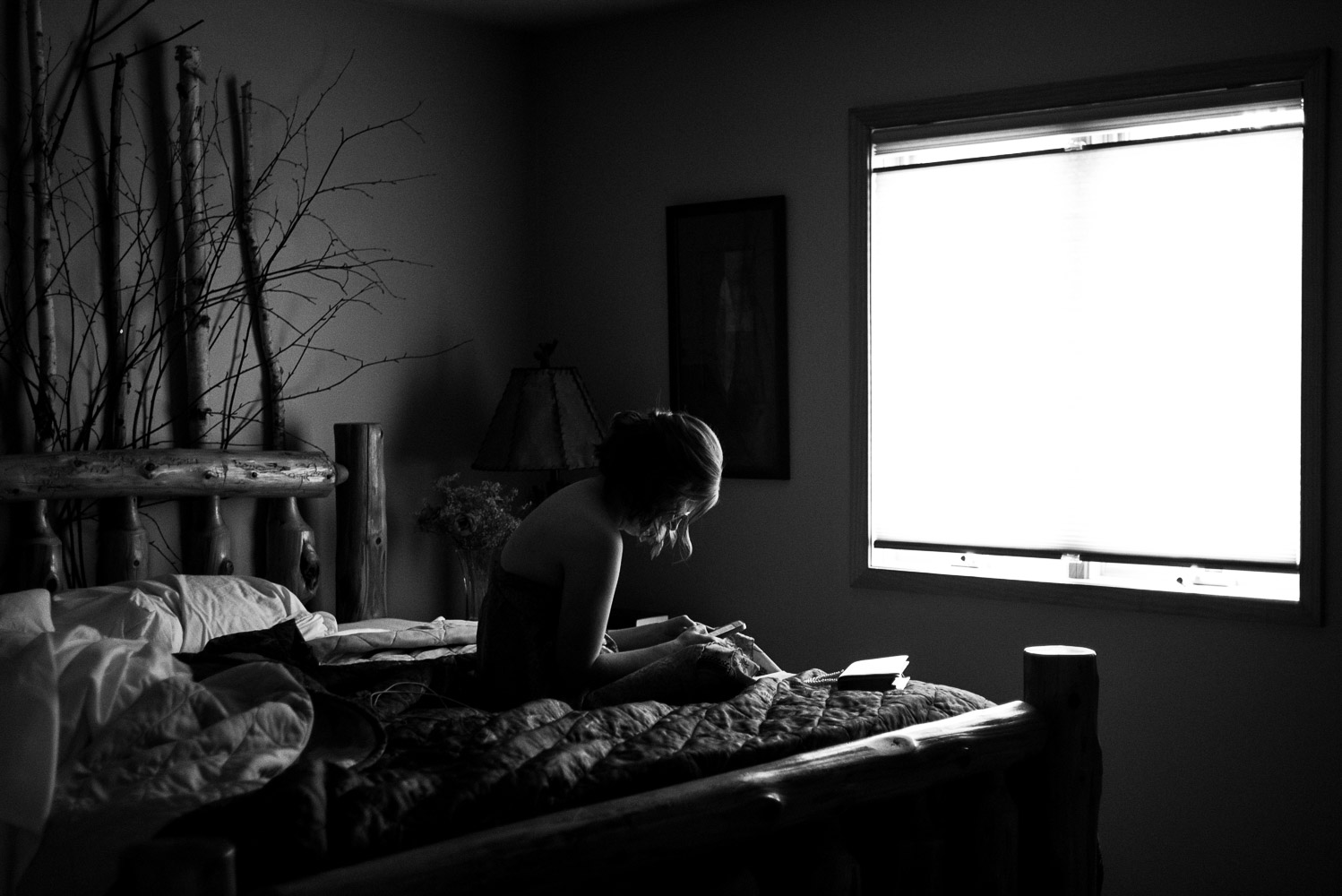 bride sitting on a bed reading a letter from the groom