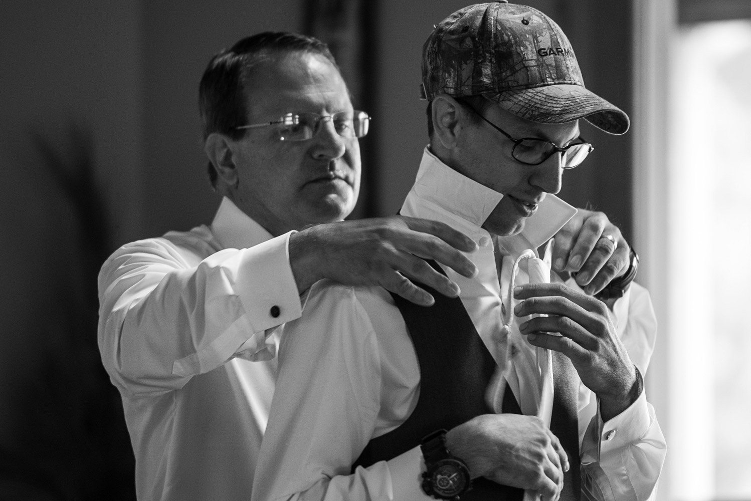 dad helping groom put his tie on for his wedding at Pine Peaks Lodge in Minnesota