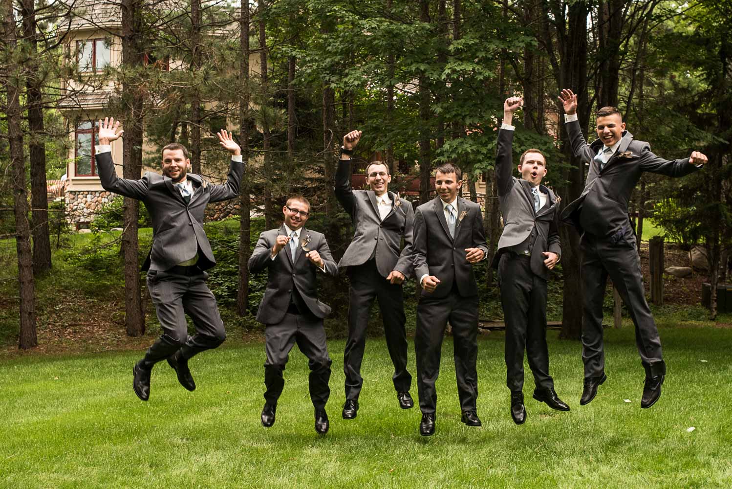 groom and the groomsmen jumping into the air before the wedding at Pine Peaks Lodge in Minnesota