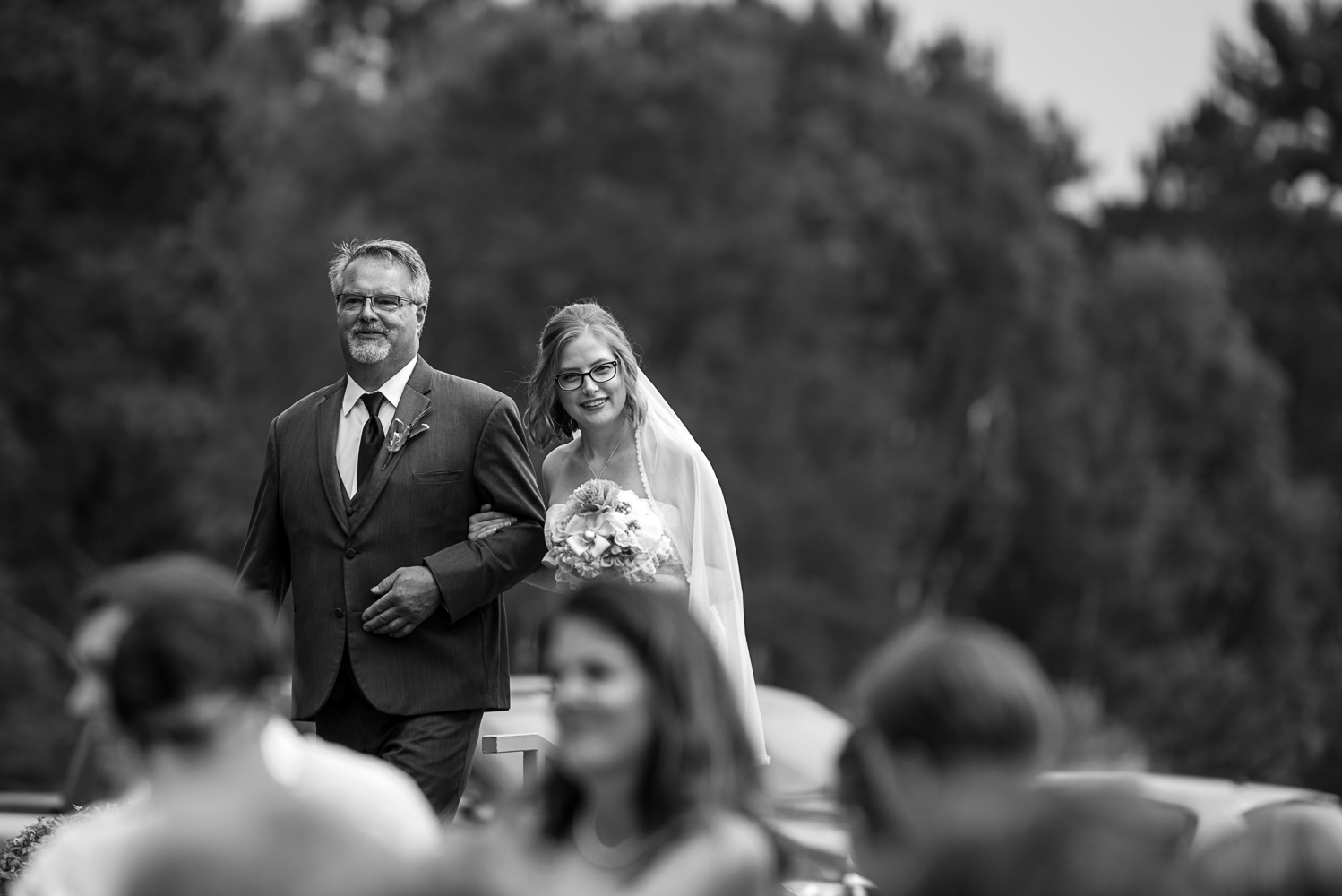bride and dad walking down the aisle during the processional at Pine Peaks Lodge in Minnesota