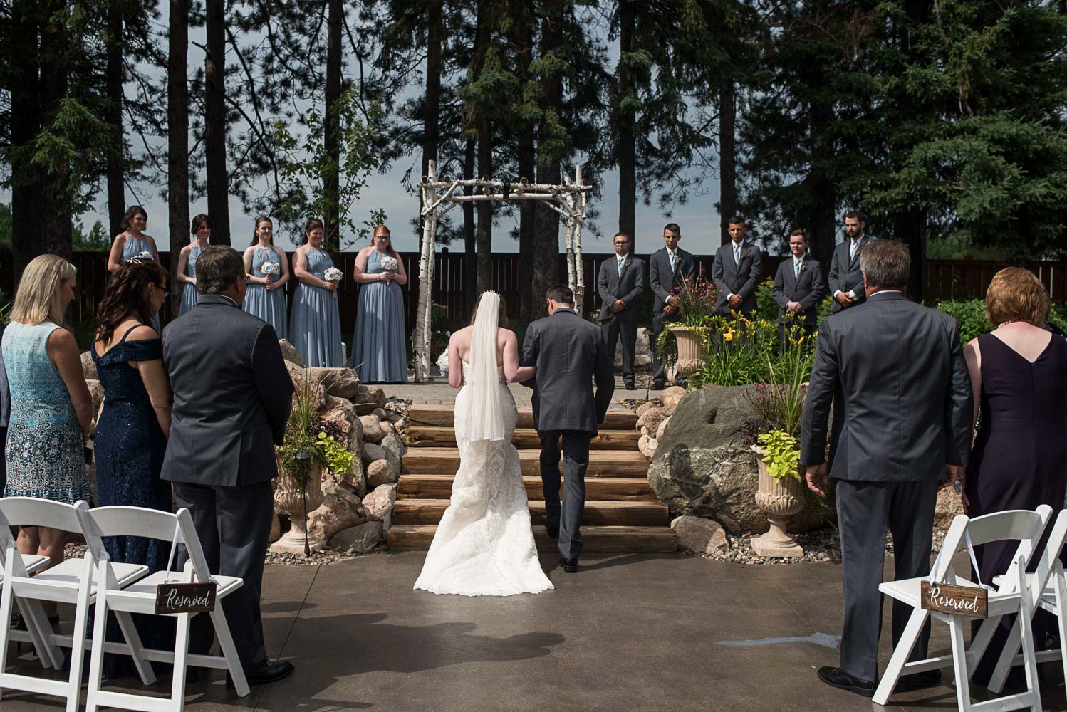 bride and father walking down the aisle for the wedding ceremony at Pine Peaks Lodge in Crosslake Minnesota