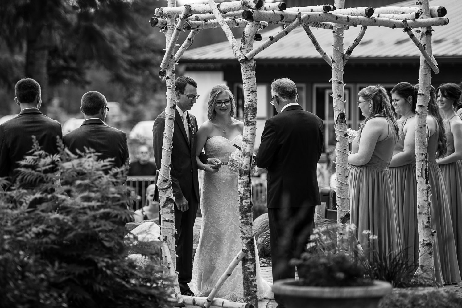 bride and groom exchanging vows during their wedding ceremony at Pine Peaks Lodge in 
