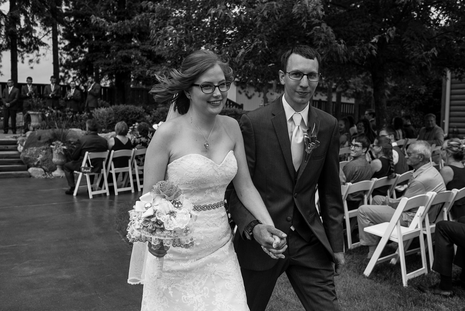 bride and groom holding hands and walking down the aisle during the recessional after their wedding ceremony at Pine Peaks Wedding and Event Center in Minnesota