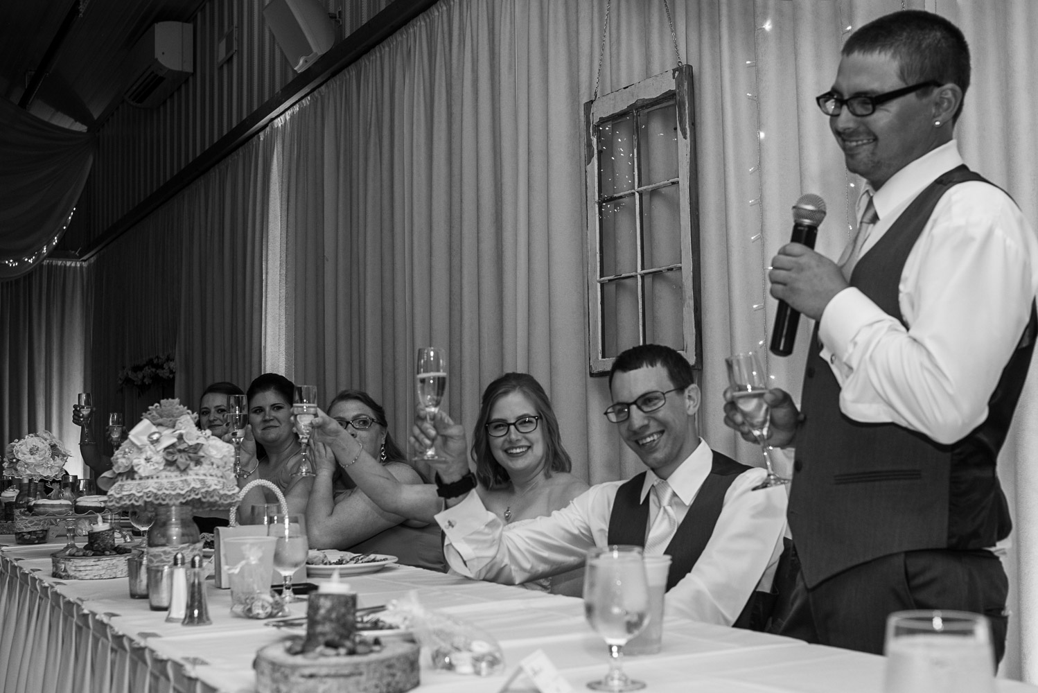 bride and groom toasting during the best man's speech at their wedding reception at Pine Peaks Wedding and Event Center in Northern Minnesota
