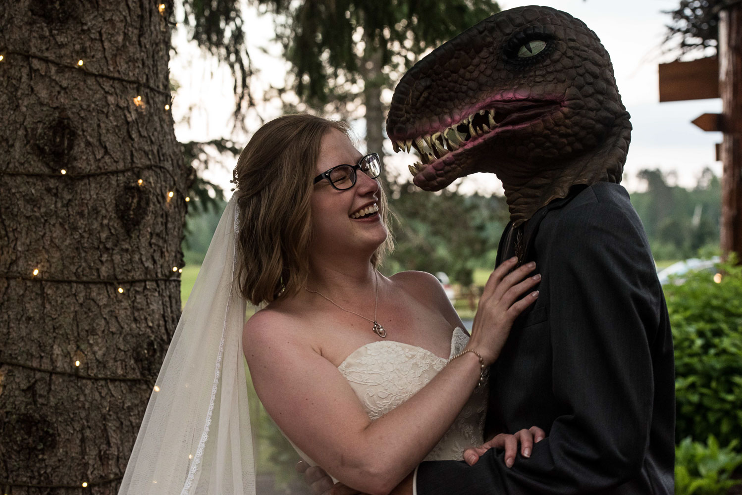 bride laughing at groom who is wearing a dinosaur mask at Pine Peaks Wedding & Event Center in Minnesota