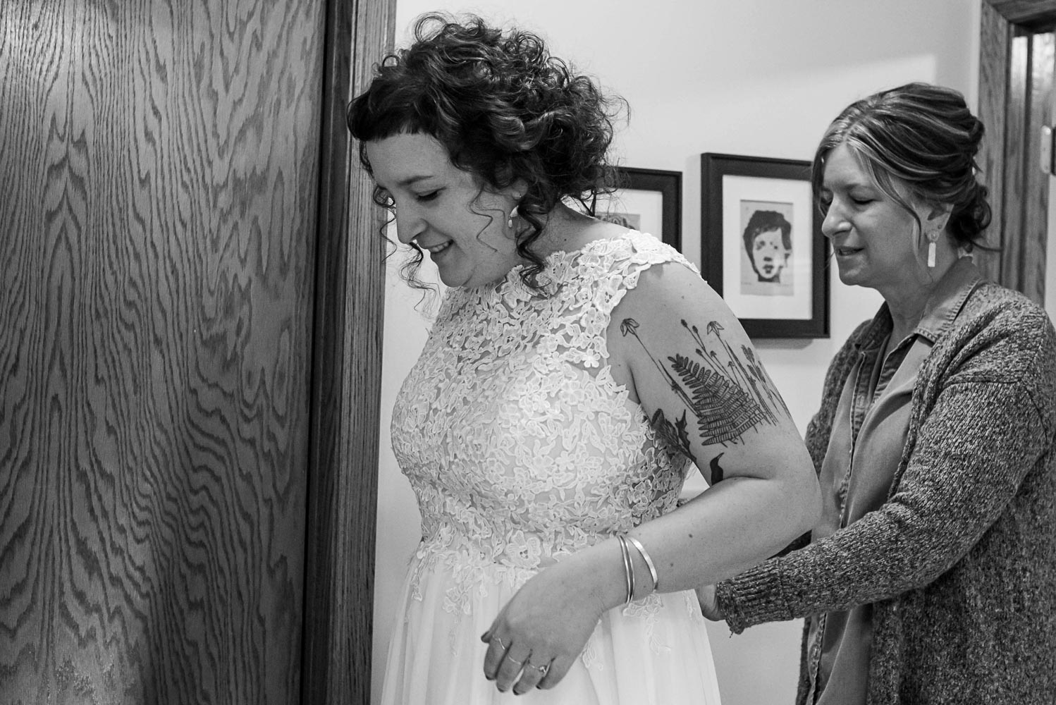 bride getting into her wedding dress with her mom helping her