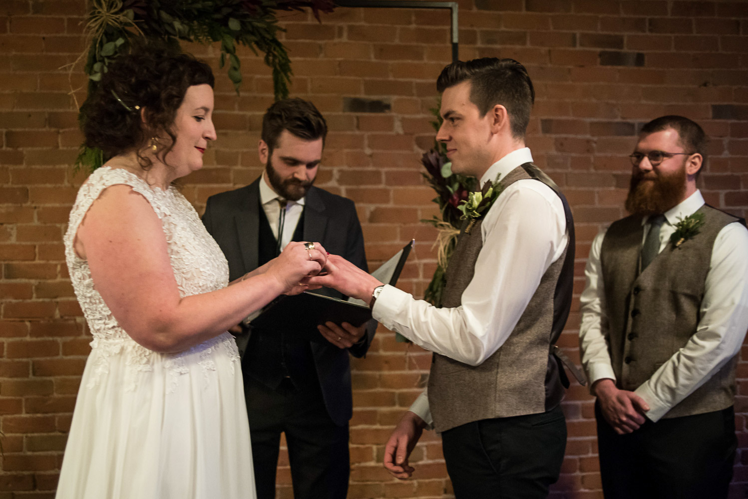 bride and groom exchanging rings during their wedding ceremony at Turtle's 1890 Social Centre